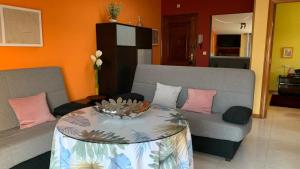 a living room with two couches and a table at Precioso ático en Playa América a 200 metros de la playa in Nigrán