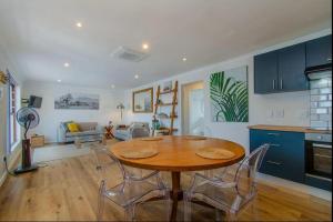 a kitchen and dining room with a table and chairs at Beachfront Bliss at Malgas Views in Gordonʼs Bay
