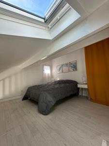 een slaapkamer met een bed en een dakraam bij La Discrète toute équipée avec piscine in Gruissan