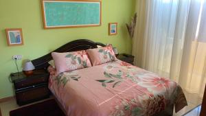 a bedroom with a bed with a pink comforter at Precioso ático en Playa América a 200 metros de la playa in Nigrán