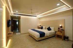 a bedroom with a large bed and a television at Hotel 6 Seasons, Koregoan Park, Pune in Pune