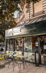 un grupo de mesas y sillas frente a una tienda en Hôtel Suzane en Angers