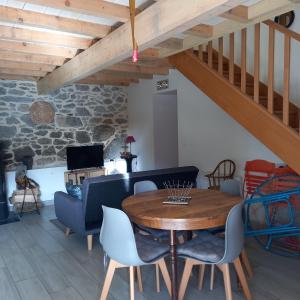 a living room with a wooden table and chairs at Les maisons d'Ustou. in Ustou