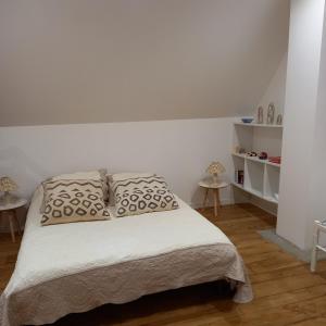 a white bedroom with a bed with two pillows at Les maisons d'Ustou. in Ustou