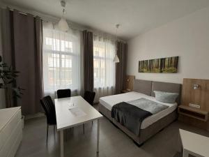 Habitación de hotel con cama, mesa y escritorio. en Deutscher Hof, en Plauen