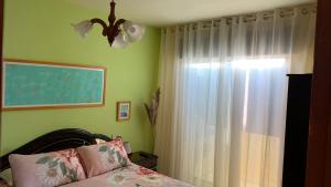 a bedroom with a bed and a window with curtains at Precioso ático en Playa América a 200 metros de la playa in Nigrán