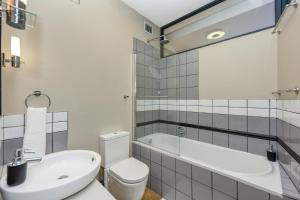 uma casa de banho com um WC, uma banheira e um lavatório. em Easy Stay - The Vantage Rosebank em Joanesburgo