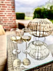 three glasses of white wine on a table at Seeliebe, 300 Meter zum Wasser, mit Terrasse und Garten in Lembruch