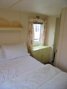 a bedroom with a white bed and a window at 8 Berth on Sealands Everglade III in Ingoldmells