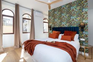 Villa Fortuny Unique Home في غرناطة: غرفة نوم مع سرير كبير مع جدار ملون