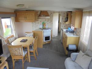 a kitchen and dining room with a table in a caravan at 8 Berth on Sealands Everglade III in Ingoldmells