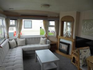 un salon avec un canapé et une cheminée dans l'établissement 8 Berth on Sealands Everglade III, à Ingoldmells