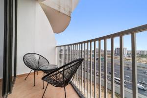a balcony with two chairs and a view of a highway at Silkhaus Luxury Studio Near Silicon Shopping Mall in Dubai