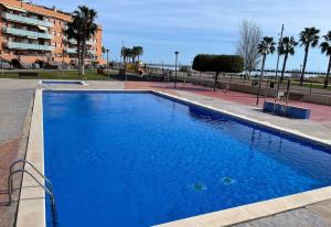 a large blue swimming pool next to a building at Apartamento La Sal Cubelles in Cubelles