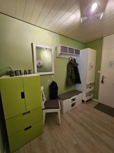 um quarto com uma parede verde com um espelho e uma cadeira em Pusteblume em Altenau