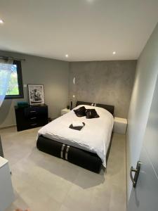 1 dormitorio con 1 cama grande con sábanas blancas en Cocon Grand Large, en Décines-Charpieu
