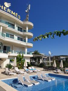 un hôtel avec des chaises longues et une piscine dans l'établissement Apartments D'Hermes, à Ulcinj