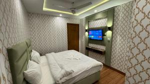 a small room with a bed and a television at Orbit Royal in Islamabad