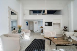 a living room with white furniture and a table at Astra House by Mykonos Mood in Mýkonos City