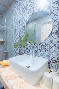 ハロンにあるNhà Mình Homestay Hạ Longの白い洗面台と鏡のあるバスルーム