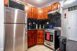 a kitchen with wooden cabinets and a stainless steel refrigerator at The Nest- 1 bedroom 1 bath convenient and cozy apartment in Brooklyn