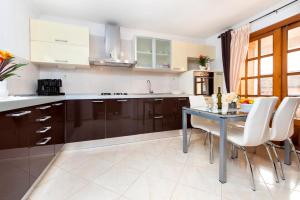 a kitchen with a table and some white chairs at Apartments Divna in Rovinj