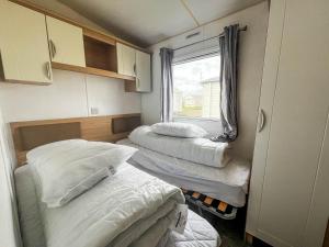 Habitación pequeña con 3 camas y ventana en Lovely 6 Berth Caravan With Free Wifi At Sand Le Mere, Yorkshire Ref 71011c, en Tunstall
