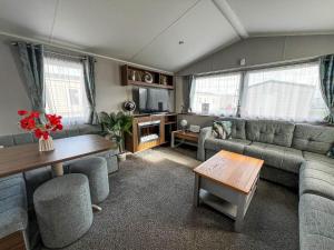 uma sala de estar com um sofá e uma mesa em Luxury Caravan With Decking And Wifi At Haven Golden Sands Ref 63069rc em Mablethorpe