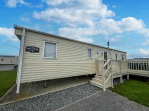 a mobile home with a porch and a sign on it at Lovely 6 Berth Caravan With Wi-fi At Sand Le Mere In Yorkshire Ref 71091td in Tunstall