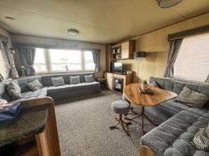 a living room with a couch and a table at Lovely 6 Berth Caravan With Wi-fi At Sand Le Mere In Yorkshire Ref 71091td in Tunstall