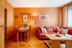 ein Wohnzimmer mit einem roten Sofa und einem Tisch in der Unterkunft Haus Beate Klein in Kröv