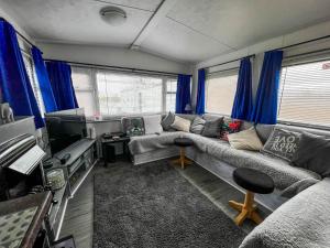 un soggiorno con divano e TV di Homely Caravan At Sand Le Mere Holiday Park Ref 71018n a Tunstall