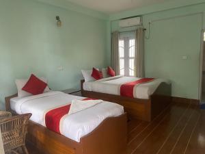 1 Schlafzimmer mit 2 Betten und einem Fenster in der Unterkunft Eco Adventure Resort in Sauraha