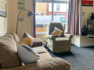 a living room with a couch and two chairs and a window at Joenina in Bridlington
