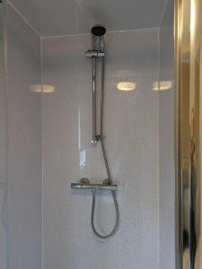 a shower with a hose attached to a wall at The Hidden Gem in Galloway Forrest in Balminnoch