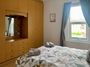 um quarto com uma cama, uma cómoda e uma janela em Joenina em Bridlington