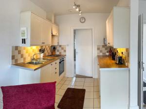 a kitchen with white cabinets and a sink at Chaplin in Legbourne