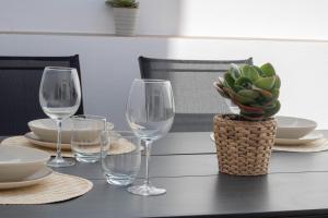 una mesa con copas de vino y una maceta en ella en Casa Da´Mar, en Marbella