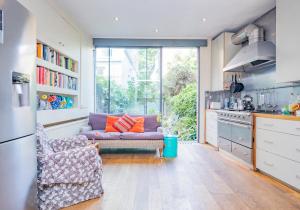 a living room with a couch and a kitchen at Beautiful Mews House - Notting Hill (pbm) in London