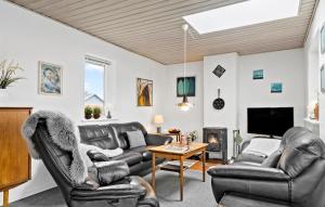 HejlsにあるAmazing Home In Hejls With House Sea Viewのリビングルーム(革製家具、テレビ付)