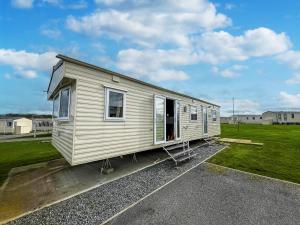 Tunstall的住宿－Lovely Caravan At Sand Le Mere Holiday Park In Yorkshire Ref 71110td，停车场里的小房子