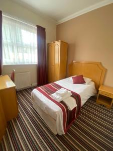 a hotel room with a bed and a window at The Lawn Hotel in Reading