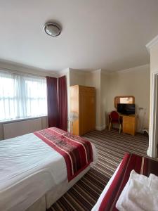 a hotel room with a bed and a television at The Lawn Hotel in Reading