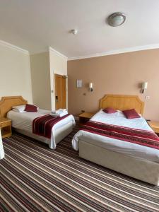 a hotel room with two beds in a room at The Lawn Hotel in Reading