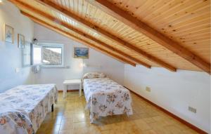 two beds in a room with a wooden ceiling at 2 Bedroom Stunning Apartment In Moneglia in Moneglia