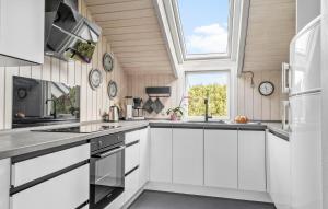 SkovbyにあるHoliday Home Egemose Sydals Denmarkの白いキャビネットと窓のあるキッチン