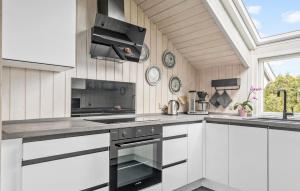 SkovbyにあるHoliday Home Egemose Sydals Denmarkの白いキャビネットとコンロ付きオーブンを備えたキッチン