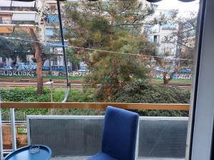 een blauwe stoel voor een raam bij Apartment near Acropolis in Athene