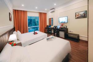 Duży pokój hotelowy z 2 łóżkami i biurkiem w obiekcie Lake View Hotel & Travel w mieście Hanoi
