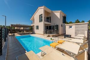 eine Villa mit Swimmingpool und ein Haus in der Unterkunft Villa Kristina ZadarVillas in Zaton